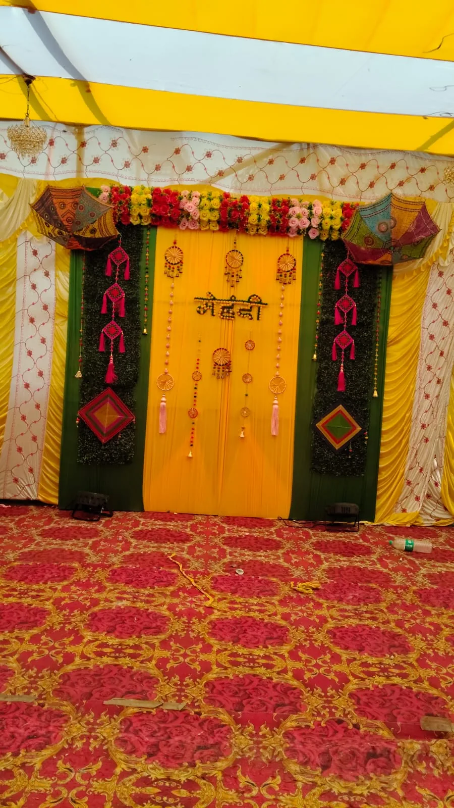 Yellow green mehendi backdrop with umbrellas decoration
